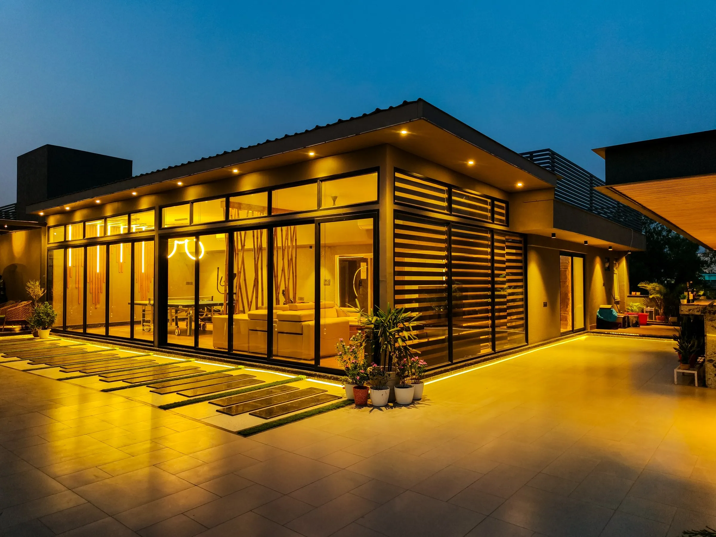 Glass pavilion and lit terrace at blue hour, designed and built by LifeWall in Delhi NCR